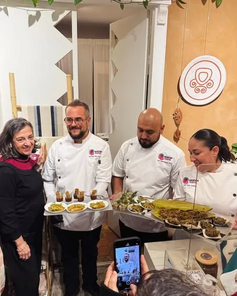 Une équipe en tablier de cuisine présentant des plats