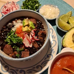 Bol de frijoles con puerco garni de radis, coriandre et avocat
